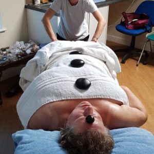Chris receiving a stone therapy massage treatment